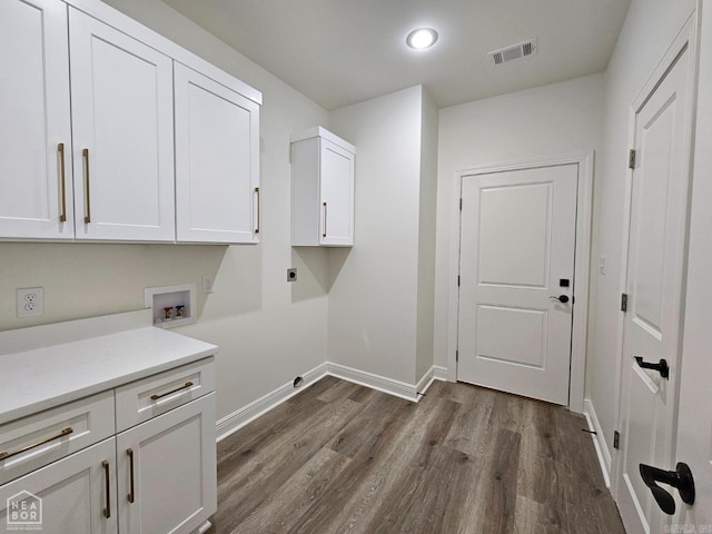 laundry area featuring cabinets, hookup for a washing machine, dark wood-type flooring, and electric dryer hookup