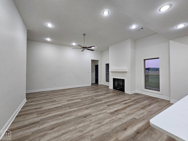 unfurnished living room with wood-type flooring and ceiling fan