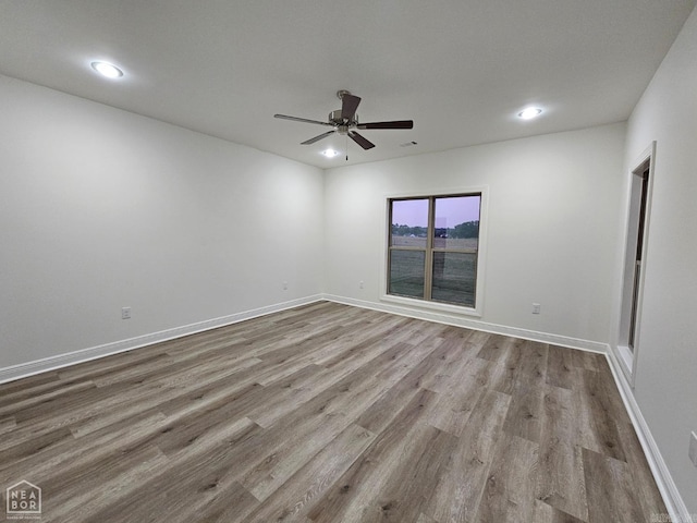 spare room with light wood-type flooring and ceiling fan