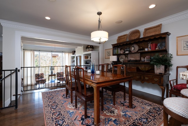 dining space with dark wood-type flooring and crown molding