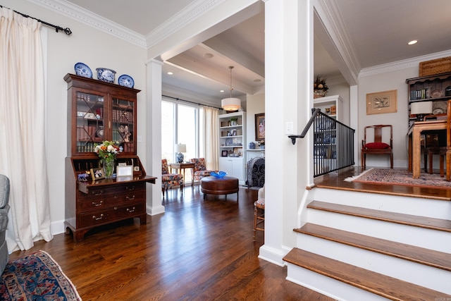 staircase with decorative columns, wood-type flooring, and ornamental molding