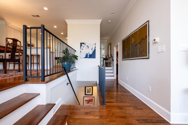 staircase featuring hardwood / wood-style floors and crown molding