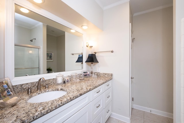 bathroom with a shower with door, vanity, tile patterned floors, and crown molding