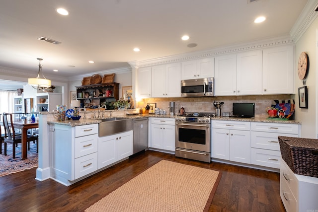 kitchen with stainless steel appliances, decorative light fixtures, dark hardwood / wood-style floors, white cabinets, and kitchen peninsula