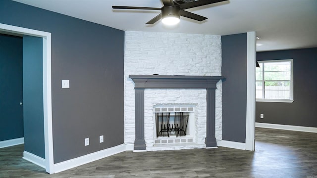 unfurnished living room with a fireplace, ceiling fan, and dark wood-type flooring