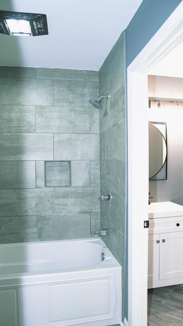 bathroom featuring wood-type flooring, vanity, and tiled shower / bath combo