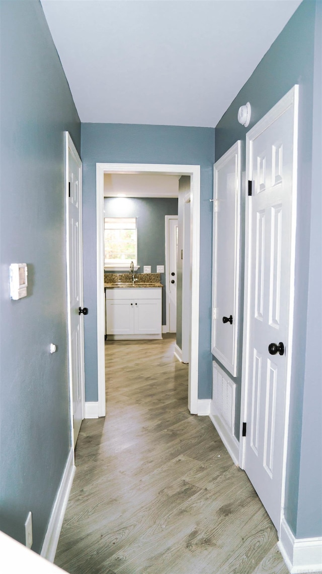 200 Pine Forest Dr Apt C2, Maumelle, AR 72113 - hallway with a sink, baseboards, and light wood-type flooring