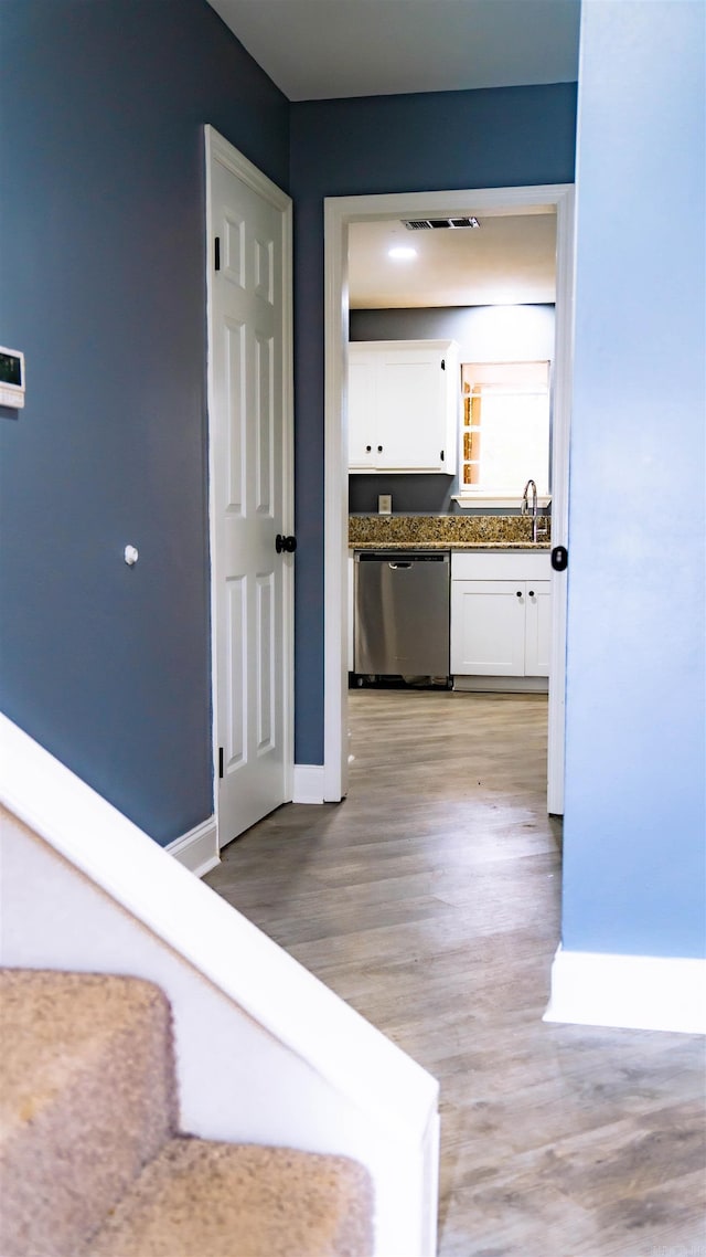 hall with light hardwood / wood-style floors and sink