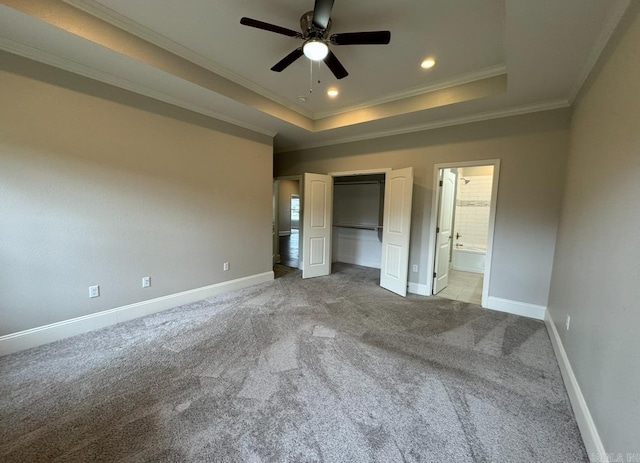 unfurnished bedroom featuring ceiling fan, ornamental molding, carpet flooring, and a tray ceiling