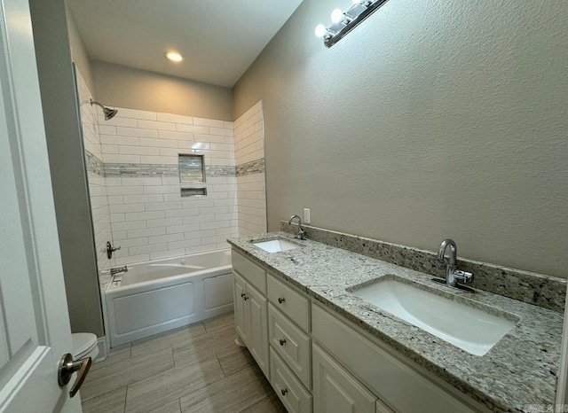 full bathroom with vanity, toilet, and tiled shower / bath combo