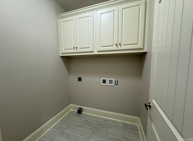 laundry room with hookup for an electric dryer, washer hookup, and cabinets