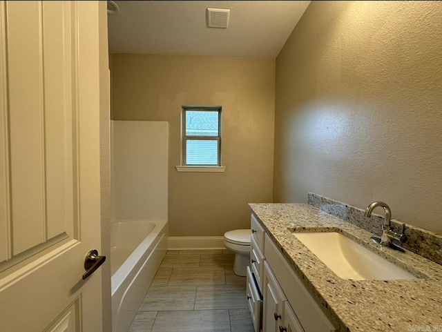 bathroom with a tub, tile patterned flooring, vanity, and toilet