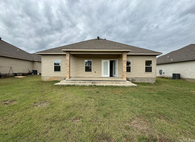 rear view of property featuring central AC unit, a patio, and a lawn