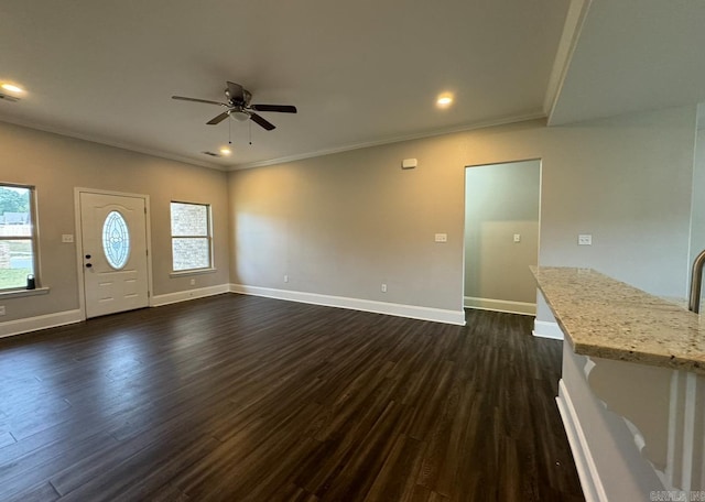 unfurnished living room with dark wood-type flooring, ceiling fan, and ornamental molding