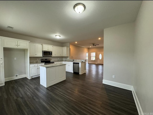 kitchen featuring kitchen peninsula, white cabinets, dark hardwood / wood-style floors, and stainless steel appliances