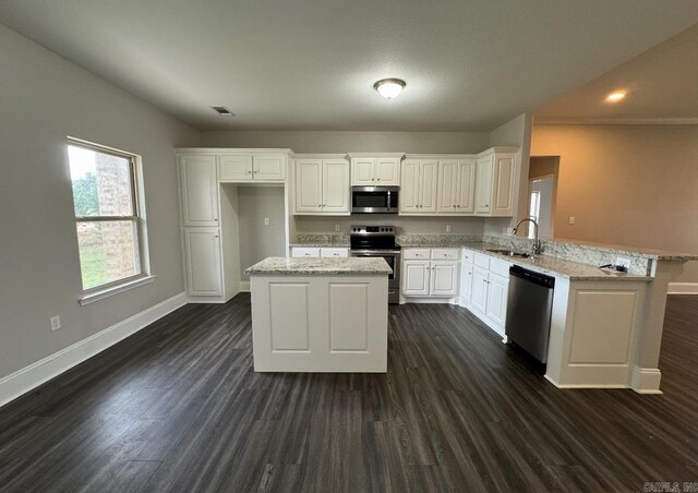 kitchen with stainless steel appliances, white cabinetry, sink, and dark hardwood / wood-style flooring