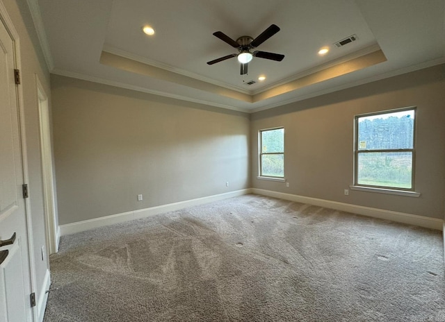 carpeted empty room with a tray ceiling, ceiling fan, and crown molding