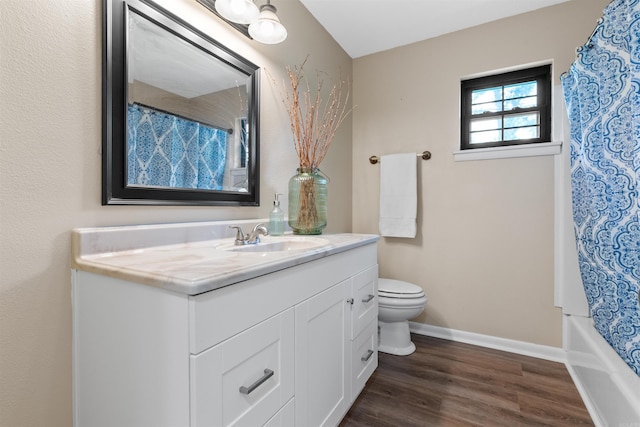 full bathroom featuring hardwood / wood-style flooring, shower / tub combo with curtain, vanity, and toilet