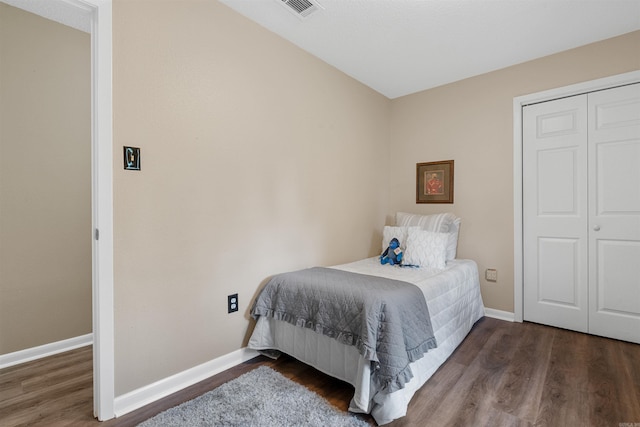 bedroom featuring dark wood-type flooring and a closet