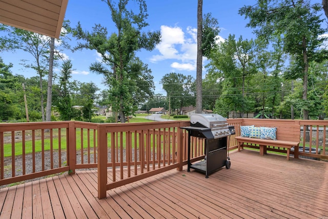 wooden terrace with a lawn and area for grilling