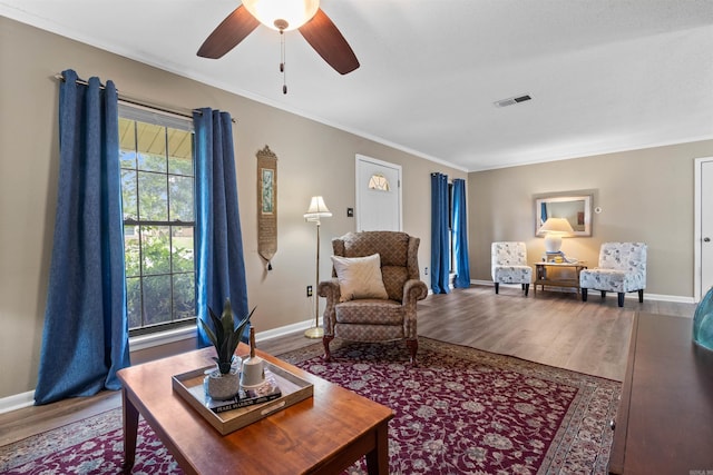 living room with hardwood / wood-style floors, ceiling fan, and crown molding