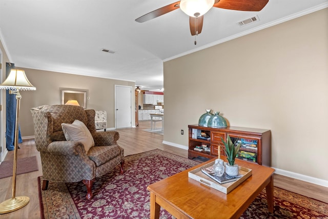 living room with hardwood / wood-style floors, ceiling fan, and ornamental molding