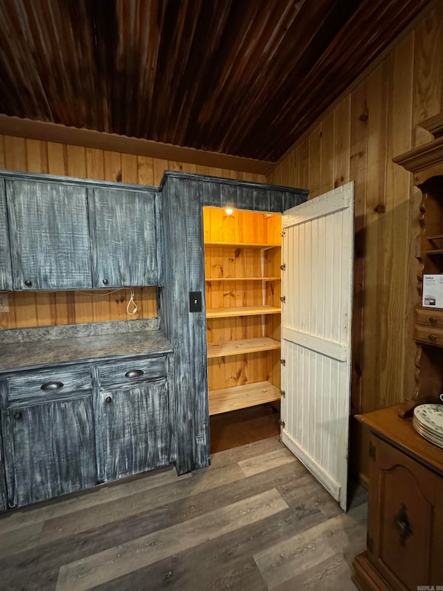 interior space with dark wood-type flooring, wooden ceiling, and wooden walls