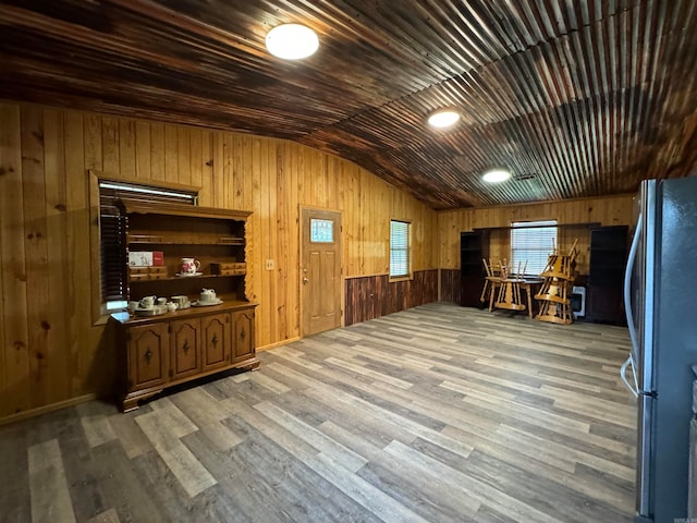 interior space featuring hardwood / wood-style floors, lofted ceiling, wooden walls, and wood ceiling