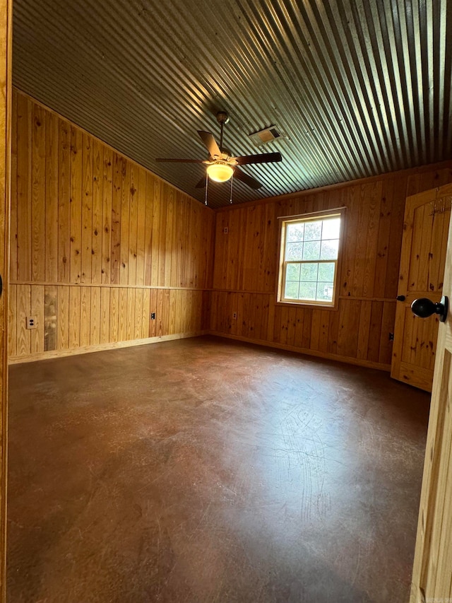 spare room featuring wooden walls and ceiling fan