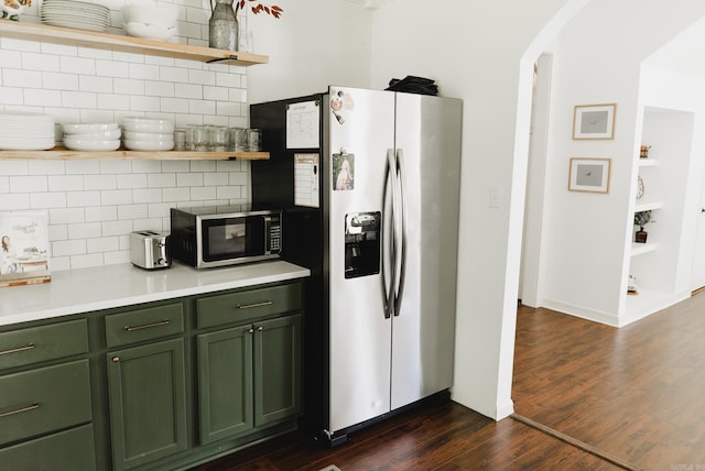 kitchen with green cabinets, stainless steel appliances, backsplash, and dark hardwood / wood-style flooring