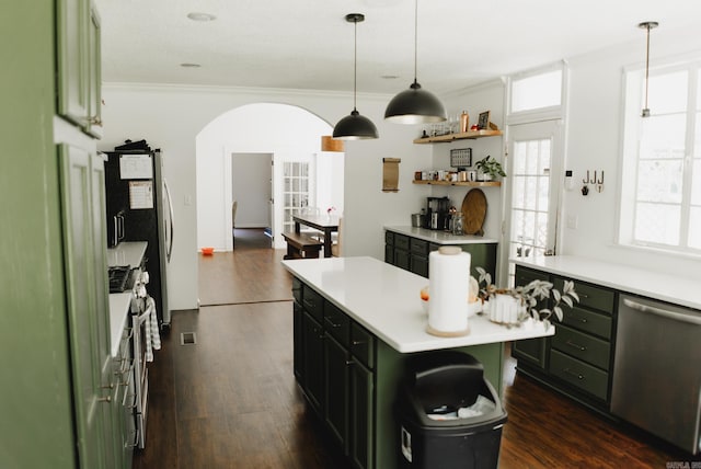 kitchen featuring dark hardwood / wood-style flooring, a center island, hanging light fixtures, crown molding, and appliances with stainless steel finishes