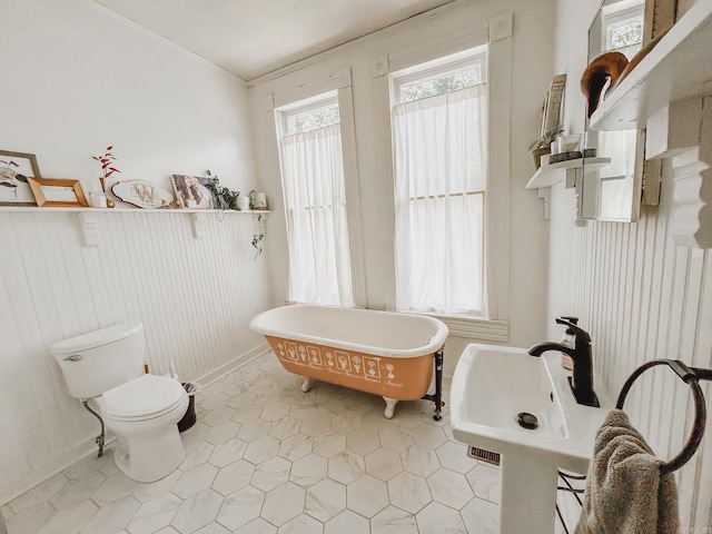 bathroom featuring toilet, a bath, and tile patterned flooring