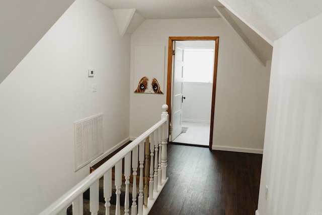 hall with dark hardwood / wood-style floors and vaulted ceiling