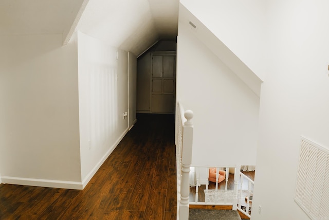 hallway with dark wood-type flooring and lofted ceiling