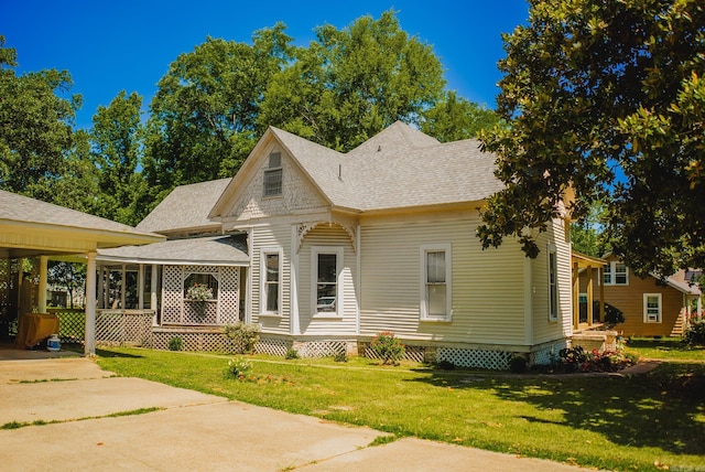 view of front of property with a front yard and a carport