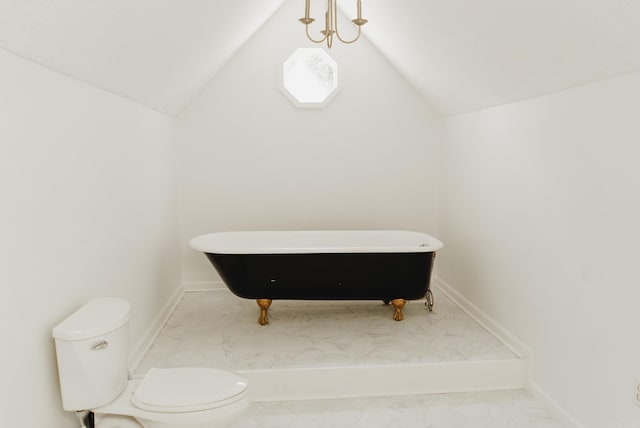 bathroom featuring a washtub, lofted ceiling, and toilet