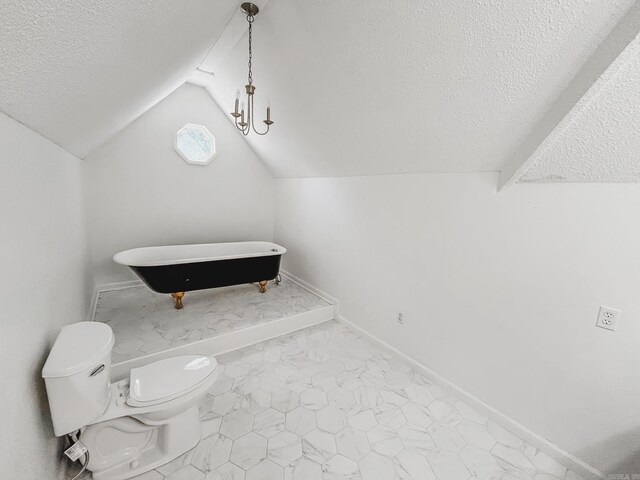 bathroom featuring lofted ceiling with beams, toilet, a textured ceiling, and a bathing tub