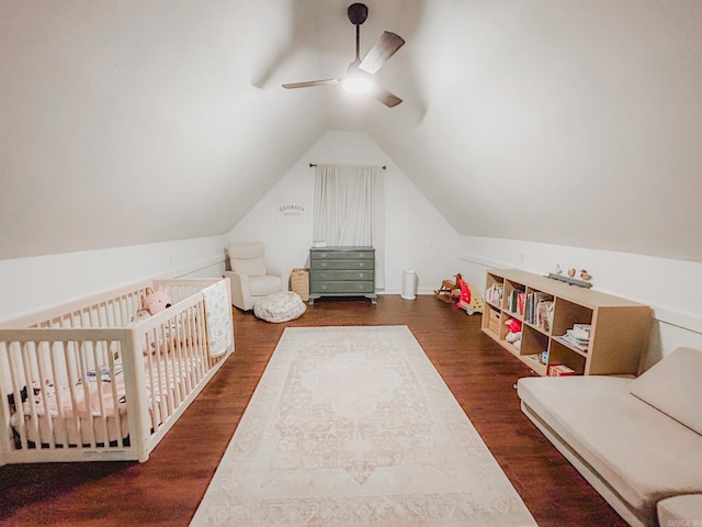 bedroom featuring ceiling fan, vaulted ceiling, dark hardwood / wood-style floors, and a crib