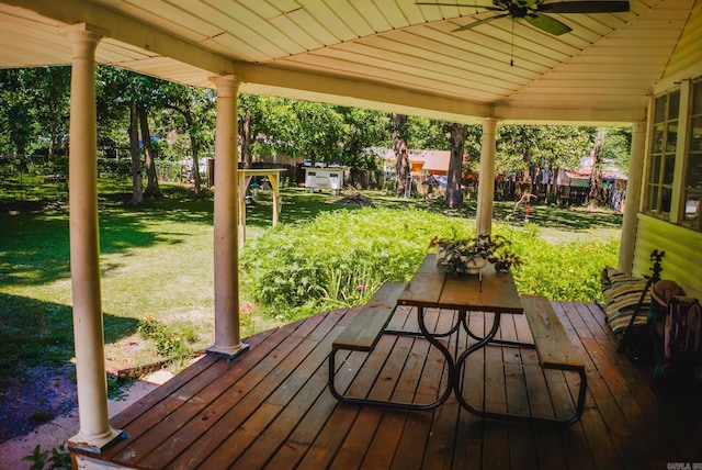 wooden deck featuring a lawn and ceiling fan