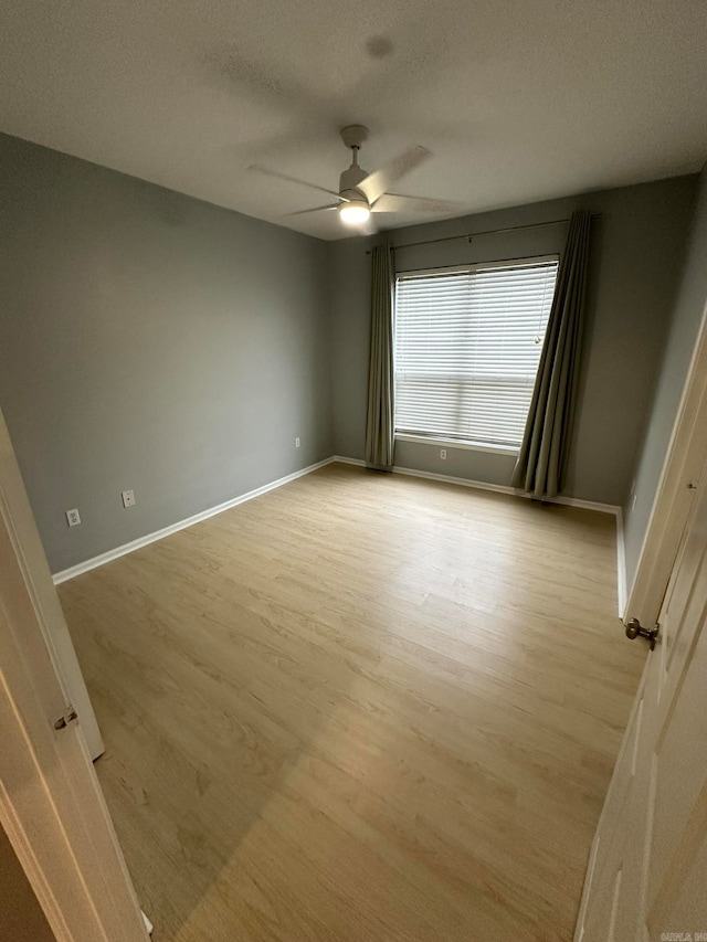 empty room featuring a textured ceiling, light hardwood / wood-style floors, and ceiling fan