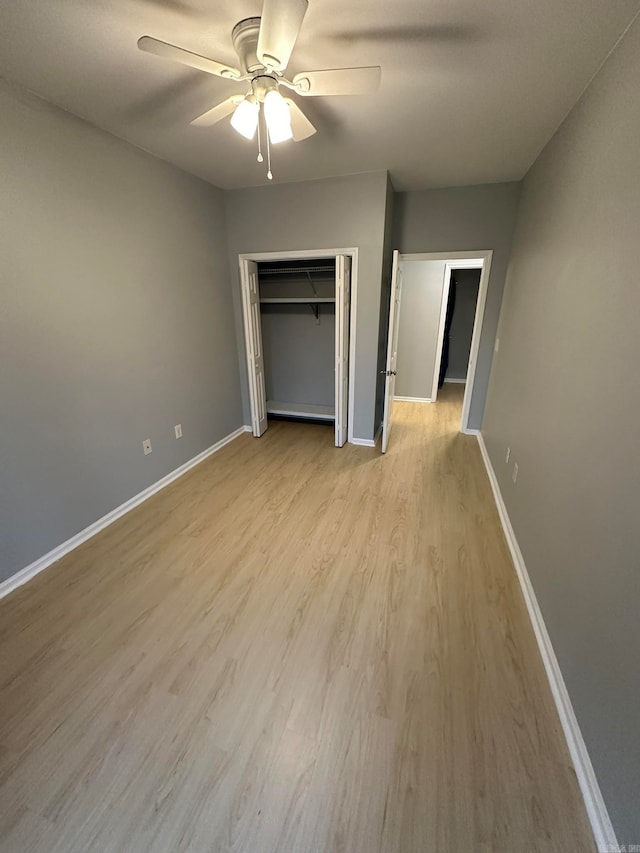 unfurnished bedroom featuring light hardwood / wood-style floors, ceiling fan, and a closet