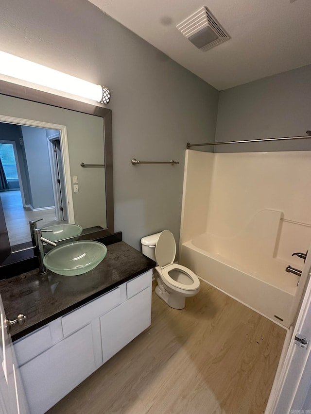 full bathroom featuring toilet, bathtub / shower combination, vanity, and hardwood / wood-style flooring