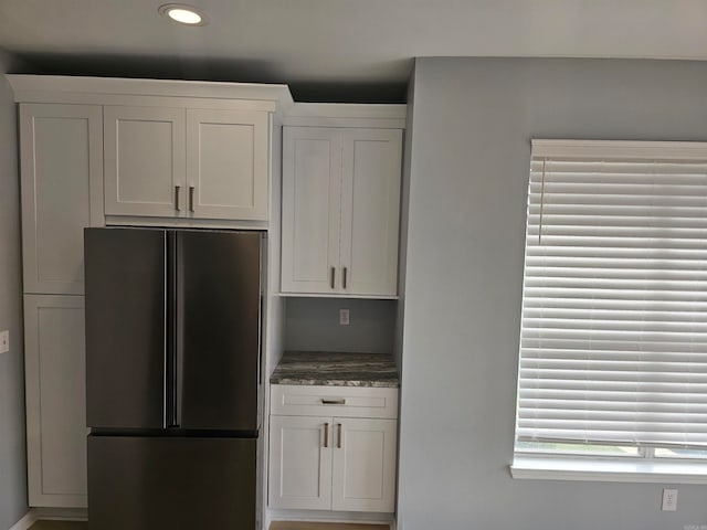 kitchen featuring white cabinets and stainless steel refrigerator