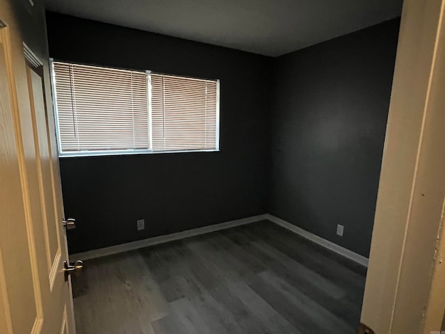 empty room with dark hardwood / wood-style flooring