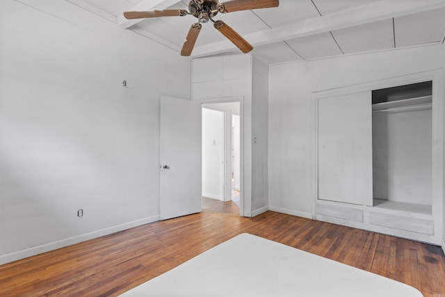 unfurnished bedroom featuring a closet, beamed ceiling, hardwood / wood-style floors, and ceiling fan