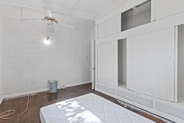 unfurnished bedroom featuring ceiling fan and dark hardwood / wood-style floors