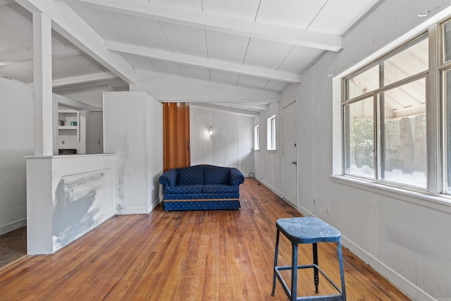 living area featuring hardwood / wood-style floors and vaulted ceiling with beams