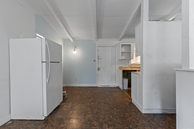 kitchen featuring beamed ceiling and white fridge