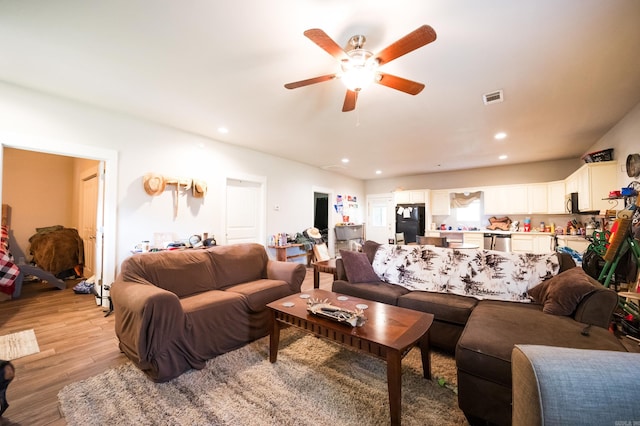 living room with light wood-type flooring and ceiling fan