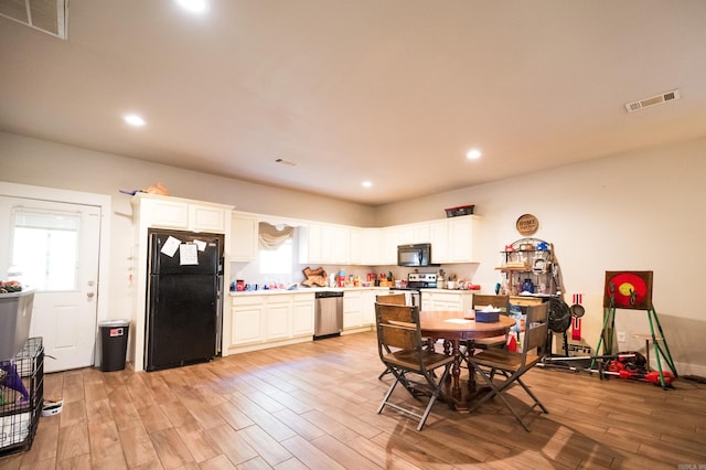 kitchen featuring black appliances, white cabinetry, and light wood-type flooring